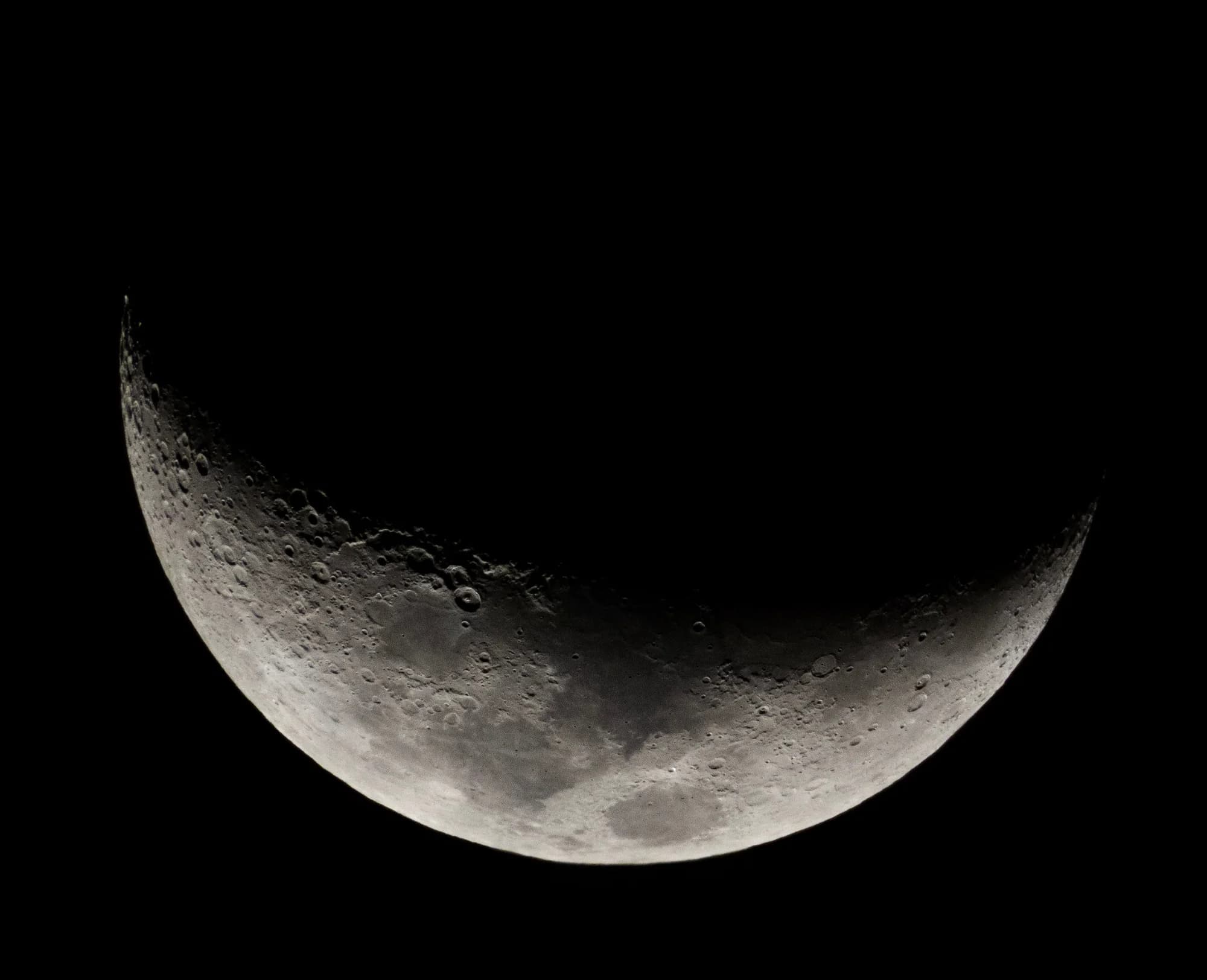 An illuminated crescent Moon against a black sky