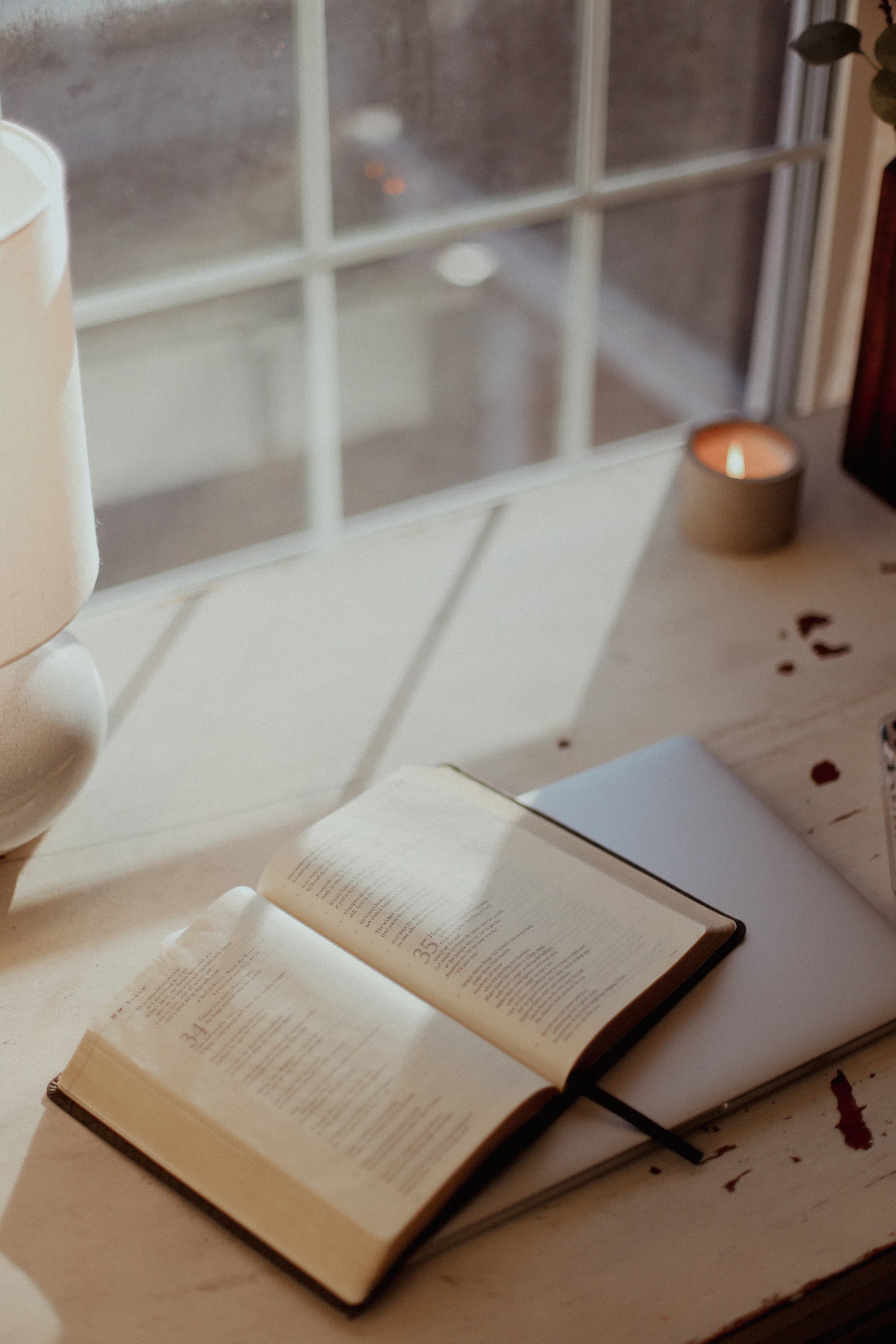 An open book and a candle on a quiet table