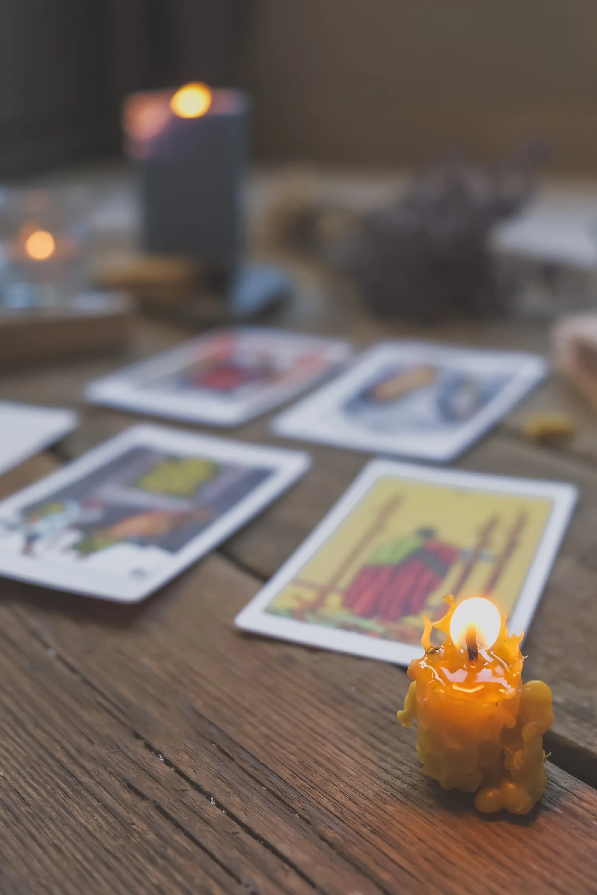 Tarot cards and a lit candle on a wooden table